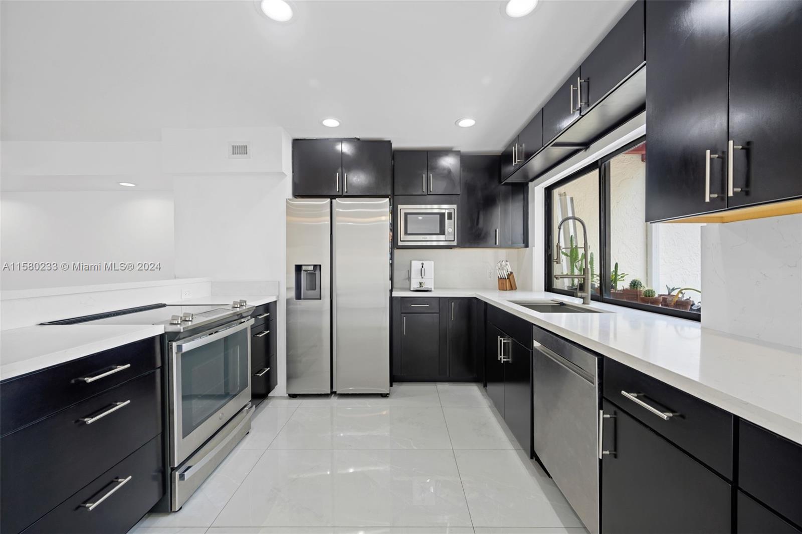 Emerald Hills Hollywood, FL 33021 - Photo 7 of 25 a kitchen with a sink stainless steel appliances and cabinets