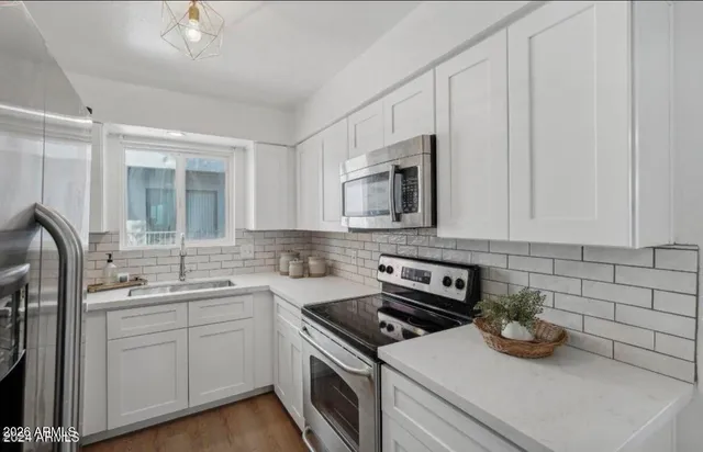 a kitchen with sink a microwave and cabinets
