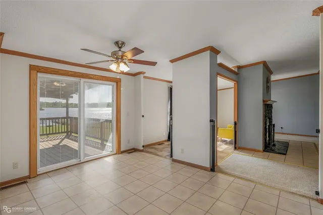 a view of a livingroom with a chandelier fan and windows