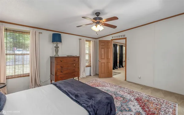 a bedroom with a bed chandelier and a window