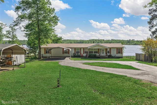a front view of house with a garden and trees