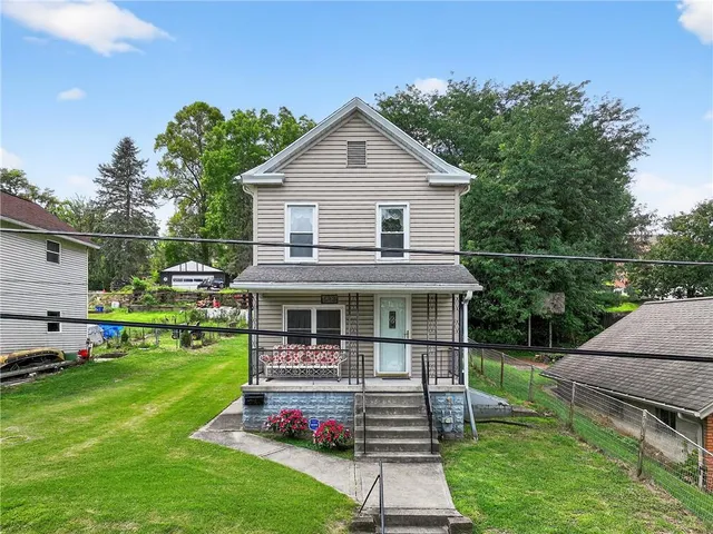 a front view of a house with a yard table and chairs