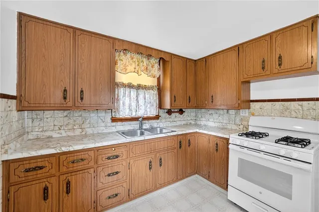 a kitchen with granite countertop a sink cabinets stainless steel appliances and a counter space