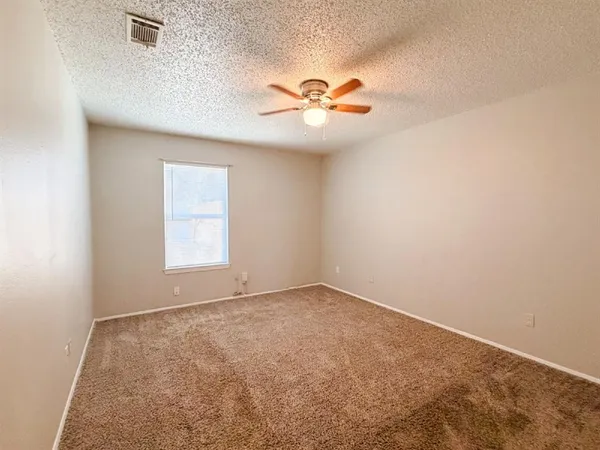 an empty room with windows and fan