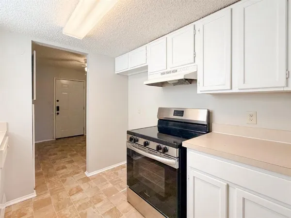 a kitchen with white cabinets and appliances
