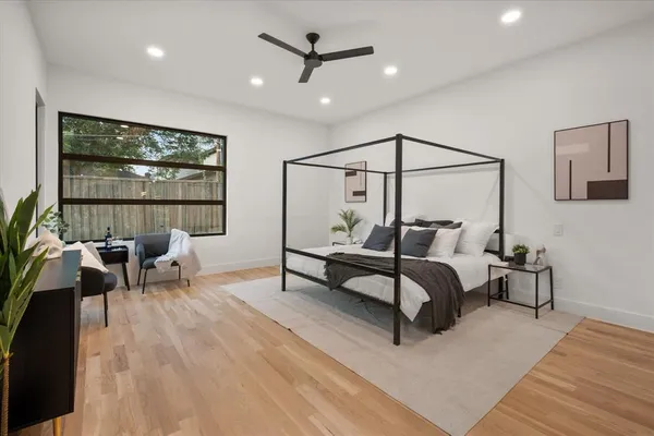 a bedroom with furniture and a large window