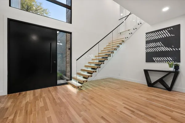a view of a livingroom with wooden floor and staircase