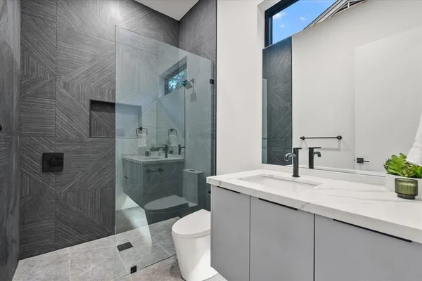 a bathroom with a sink a toilet and shower