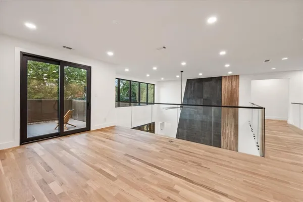 a view of empty room with wooden floor and a floor to ceiling window