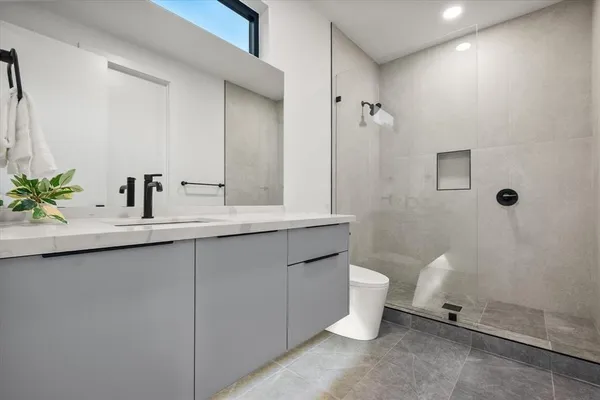 a bathroom with a granite countertop sink a toilet and a mirror