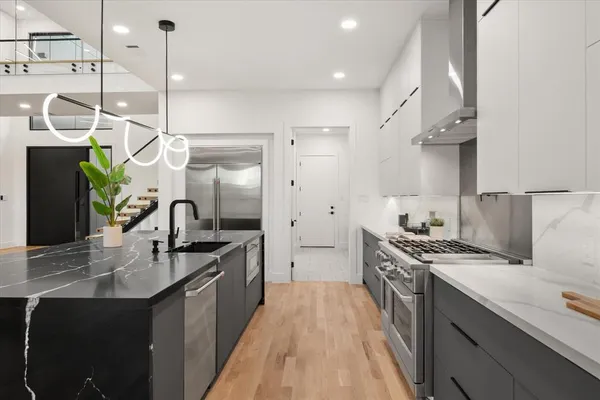 a kitchen with stainless steel appliances granite countertop a sink a stove and a refrigerator