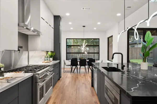 a kitchen with granite countertop a stove a sink a counter space and dining table