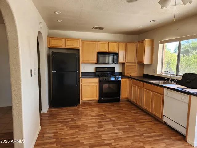 a kitchen with stainless steel appliances granite countertop a refrigerator and a sink