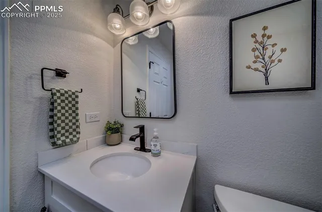 a bathroom with a toilet a sink and mirror