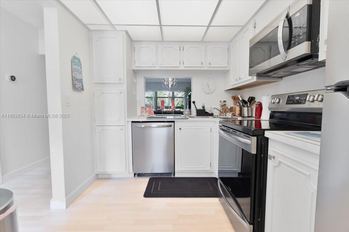 1501 South Ocean Boulevard, Unit 227 Lauderdale-by-the-Sea, FL 33062 - Photo 12 of 23 a kitchen with cabinets and stainless steel appliances