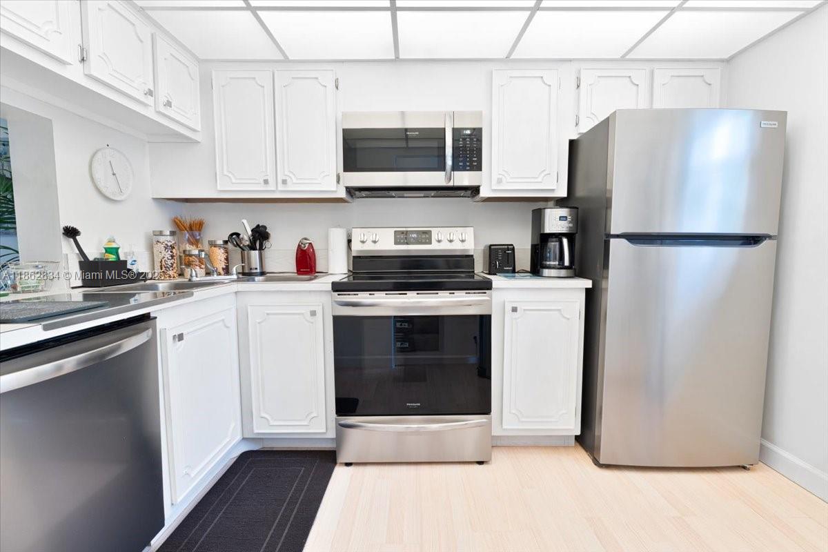 1501 South Ocean Boulevard, Unit 227 Lauderdale-by-the-Sea, FL 33062 - Photo 14 of 23 a kitchen with stainless steel appliances a refrigerator stove and microwave