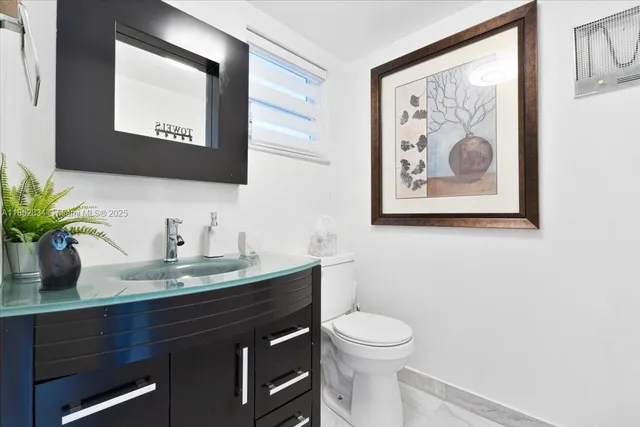 a bathroom with a toilet a sink and mirror