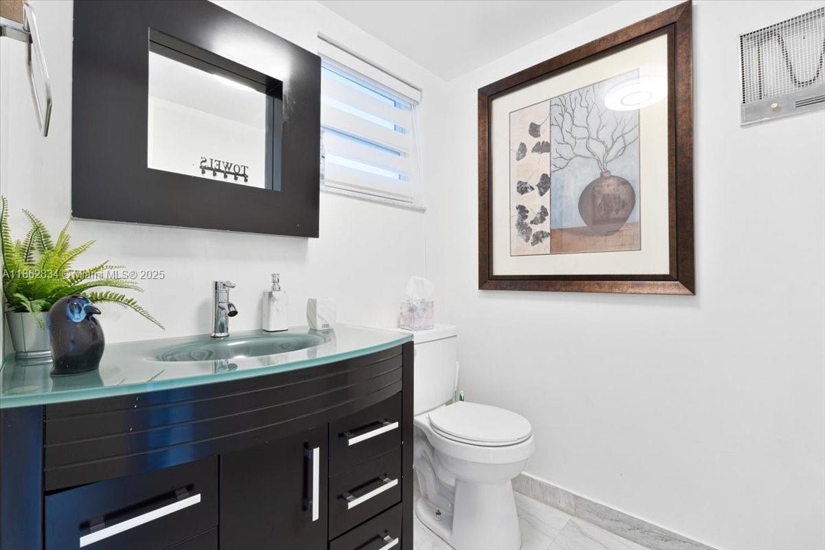 1501 South Ocean Boulevard, Unit 227 Lauderdale-by-the-Sea, FL 33062 - Photo 15 of 23 a bathroom with a toilet a sink and mirror