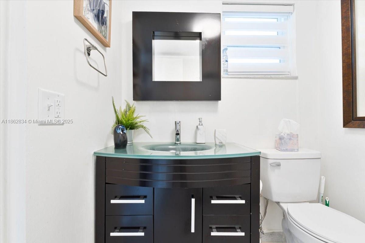 1501 South Ocean Boulevard, Unit 227 Lauderdale-by-the-Sea, FL 33062 - Photo 16 of 23 a bathroom with a toilet a sink and mirror