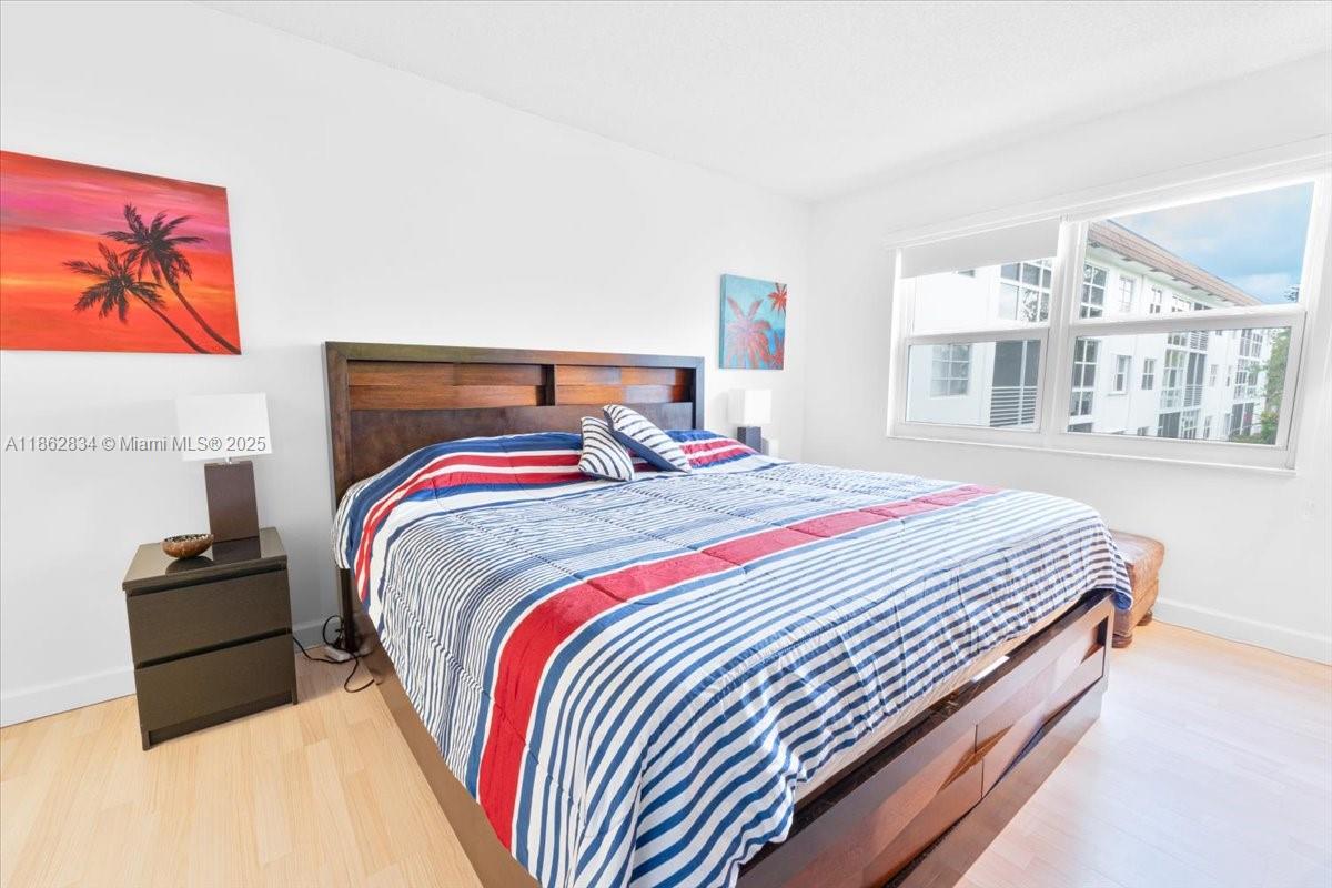 1501 South Ocean Boulevard, Unit 227 Lauderdale-by-the-Sea, FL 33062 - Photo 17 of 23 a bedroom with bed and a night stand