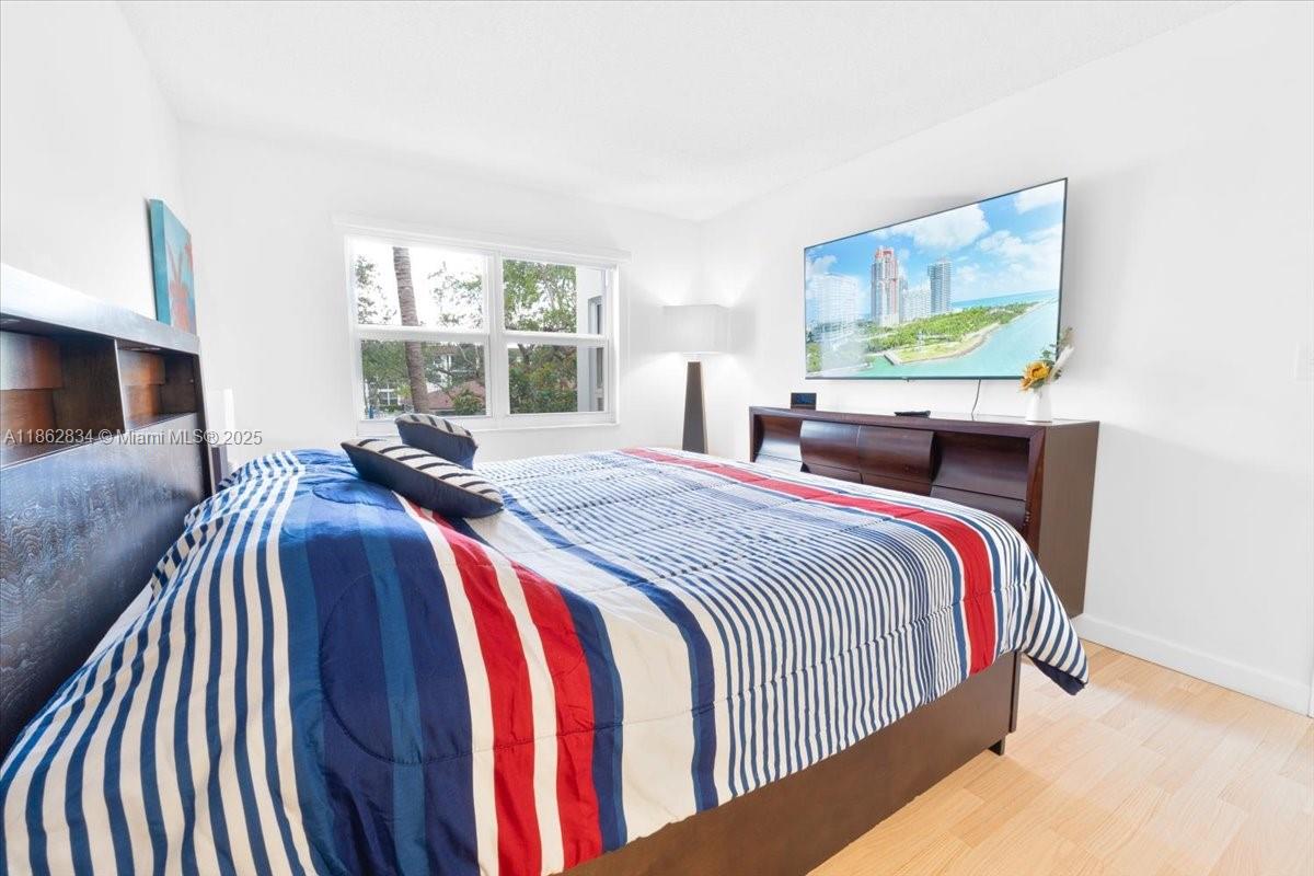 1501 South Ocean Boulevard, Unit 227 Lauderdale-by-the-Sea, FL 33062 - Photo 18 of 23 a bed sitting in a bedroom next to a window