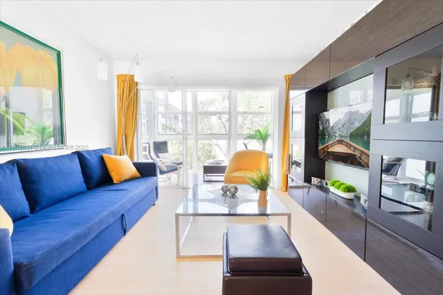 a living room with furniture and a floor to ceiling window