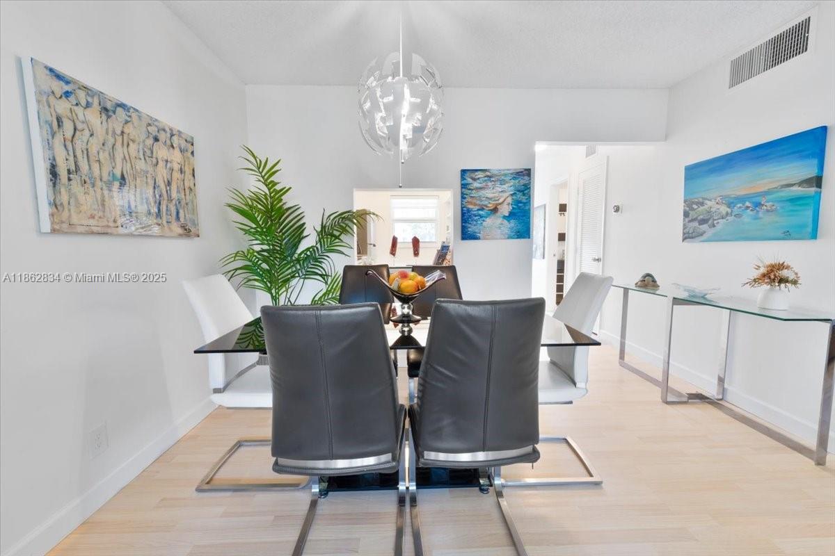1501 South Ocean Boulevard, Unit 227 Lauderdale-by-the-Sea, FL 33062 - Photo 10 of 23 a view of a dining room with furniture and a chandelier