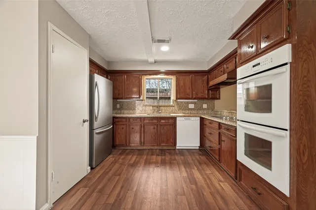 a kitchen with stainless steel appliances granite countertop a stove sink and cabinets