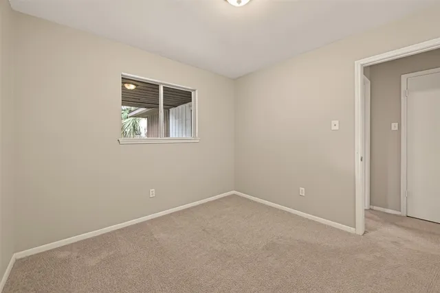 an empty room with a fan & a ceiling fan