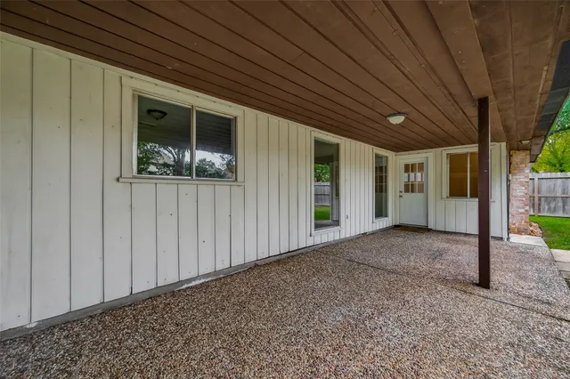 a view of a backyard with a large tree and wooden fence
