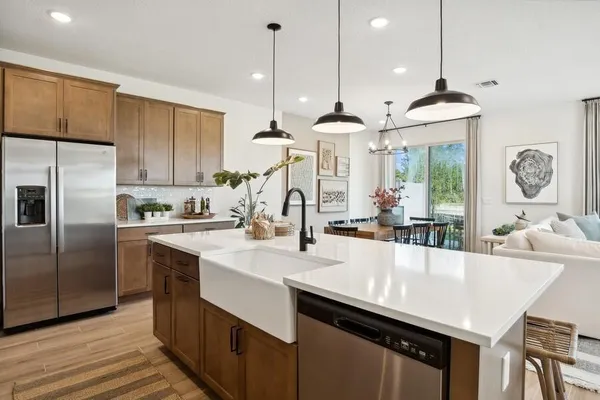 a kitchen with granite countertop a sink a center island stainless steel appliances and cabinets