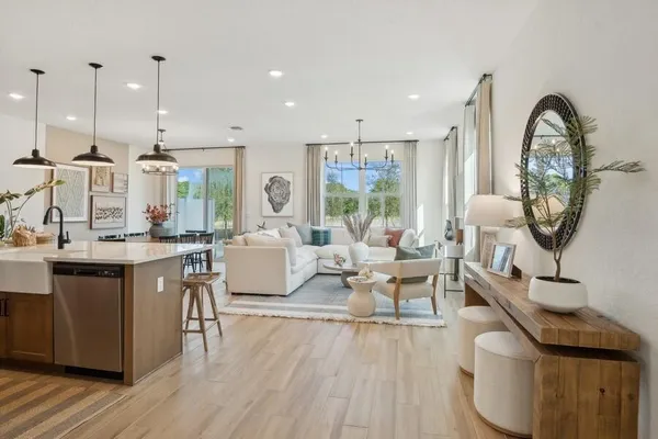 a living room with furniture a large window and wooden floor