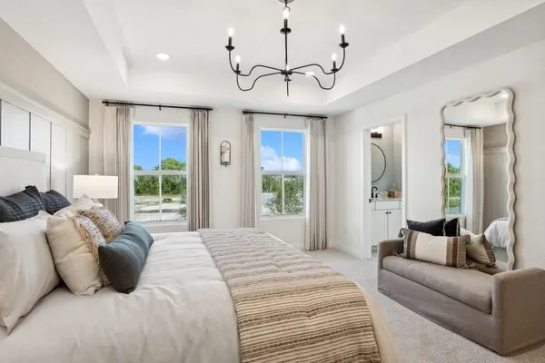 a bedroom with a large bed and a chandelier
