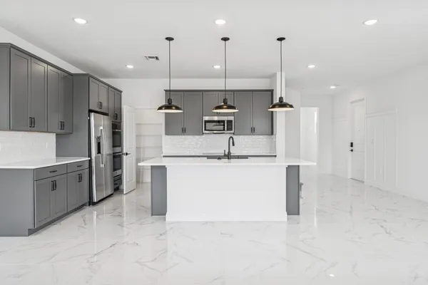 a large kitchen with cabinets and stainless steel appliances