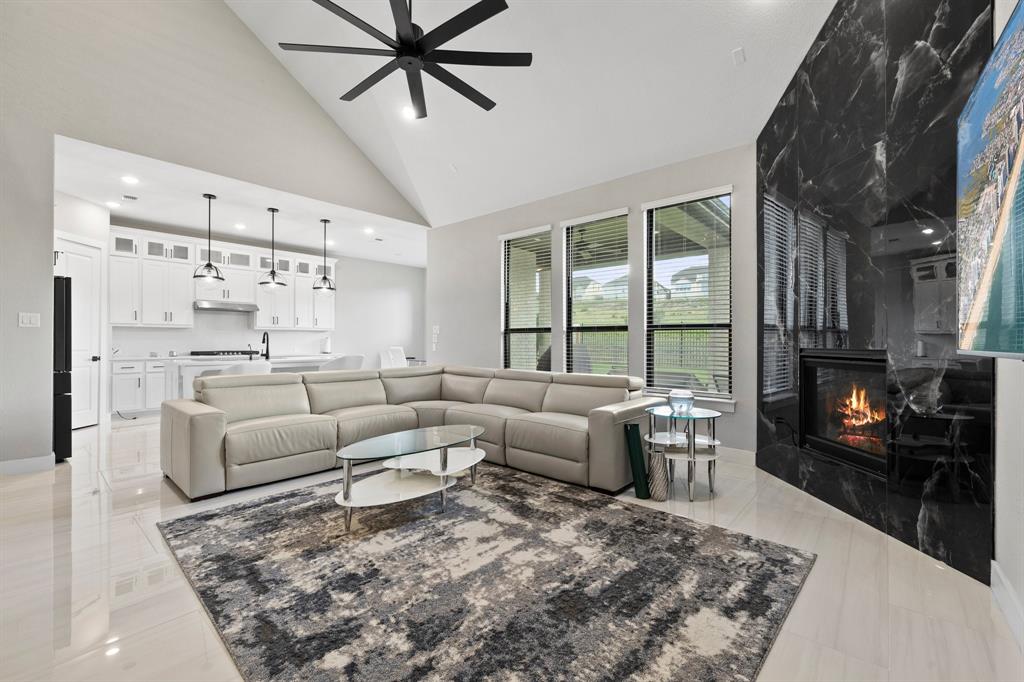 1008 Willie Rnch Way Leander, TX 78641 - Photo 12 of 40 Living room with a ceiling fan, vaulted ceiling, a fireplace, and recessed lighting