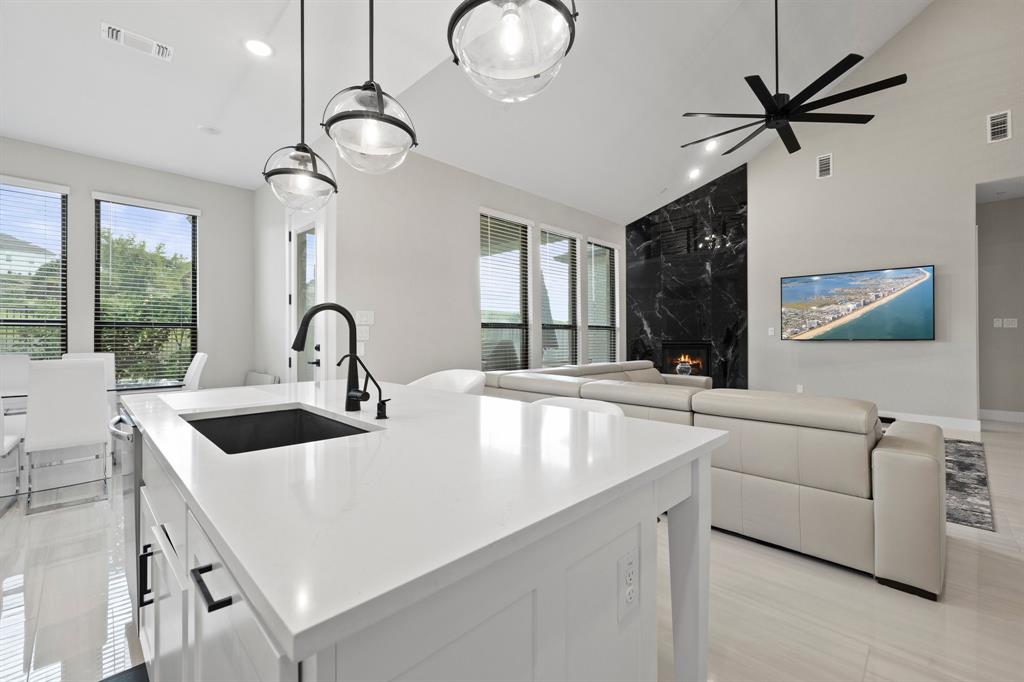 1008 Willie Rnch Way Leander, TX 78641 - Photo 38 of 40 Kitchen with vaulted ceiling, white cabinetry, pendant lighting, open floor plan, and light stone counters