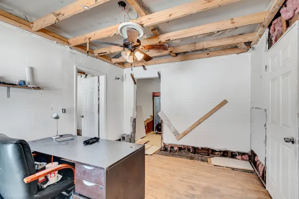a living room with table chairs and a wooden floor