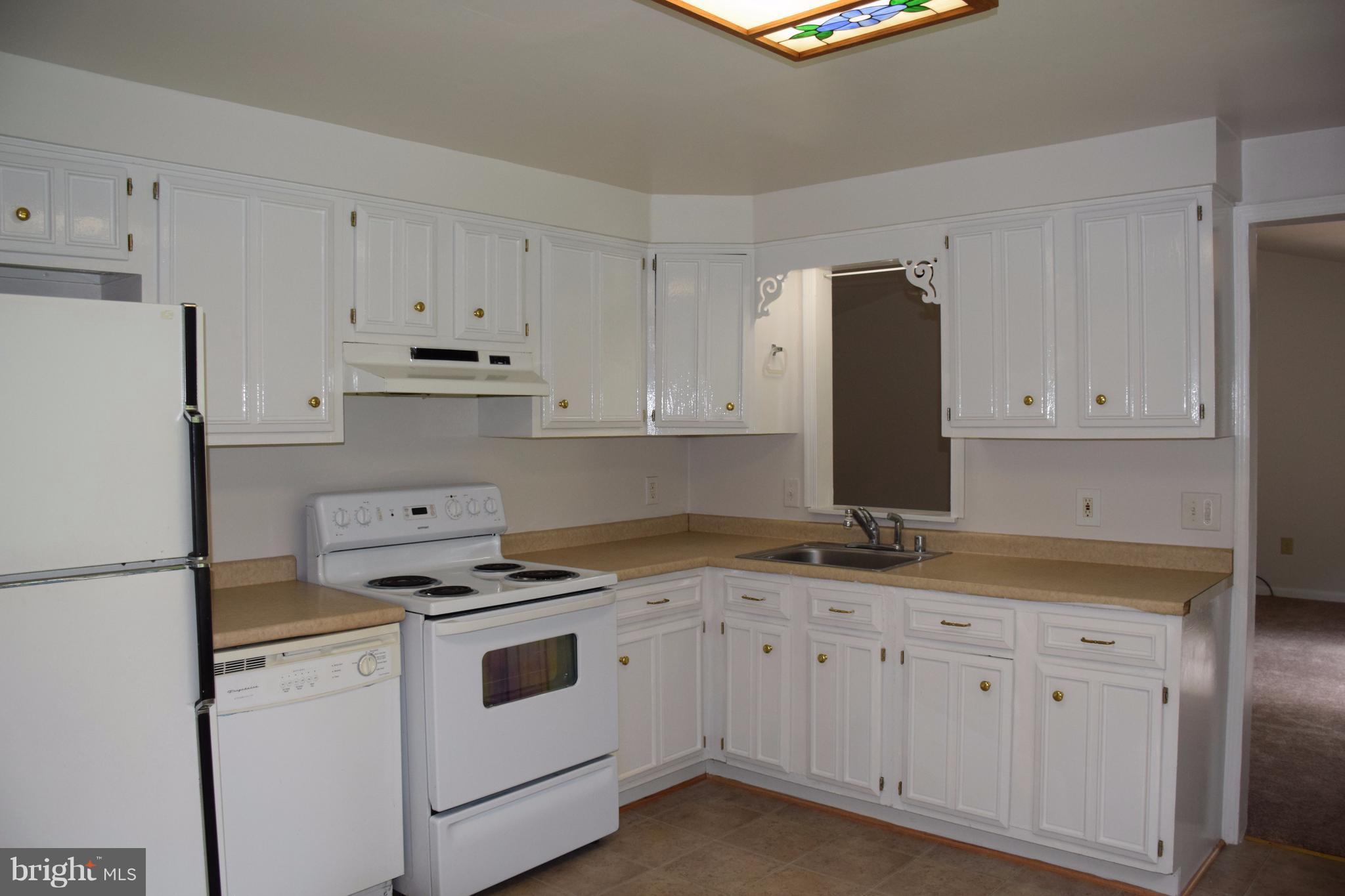 2471 Hallowing Point Road Prince Frederick, MD 20678 - Photo 9 of 30 a kitchen with granite countertop white cabinets and white appliances