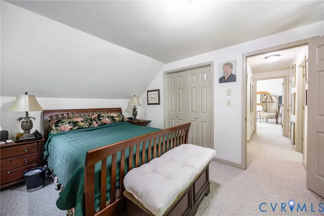 a bedroom with a bed a dresser and potted plants with the wooden floor