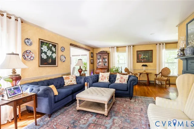a dining room with furniture a chandelier and wooden floor