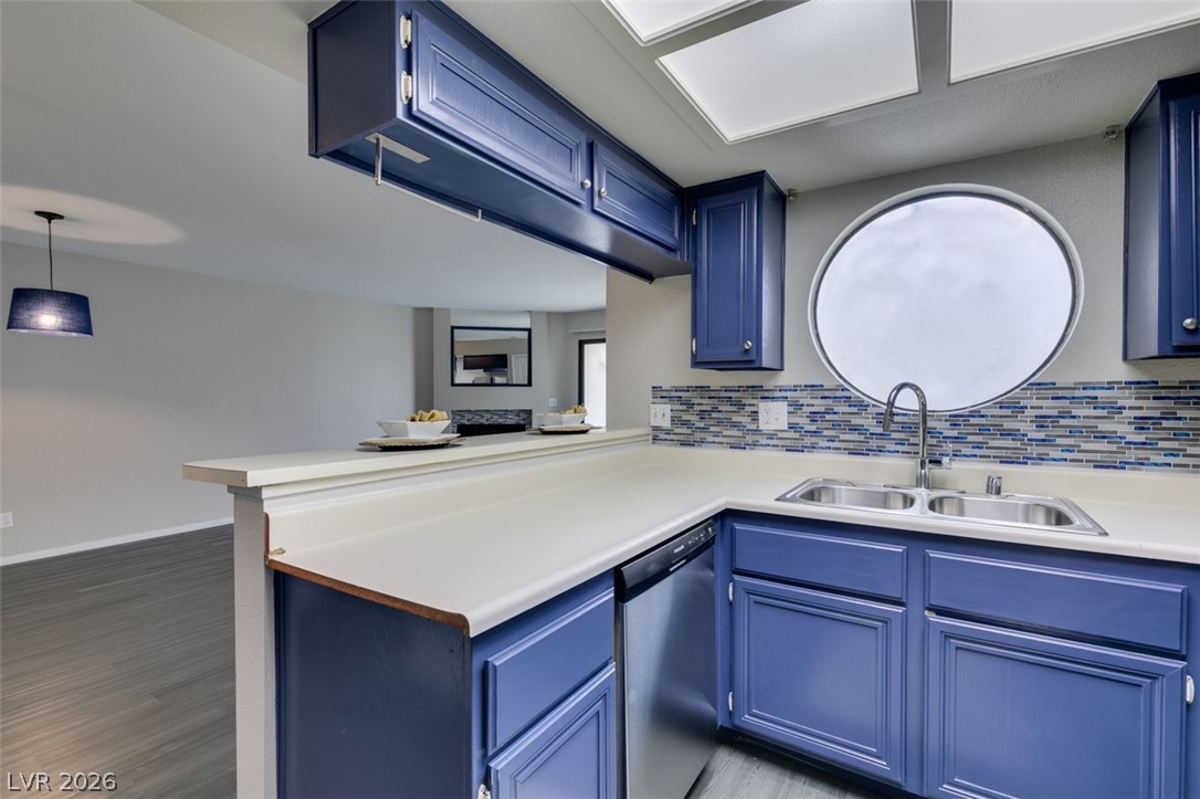 810 North Sloan Lane, Unit 103 Las Vegas, NV 89110 - Photo 11 of 16 Kitchen with dishwasher, a sink, blue cabinets, and tasteful backsplash