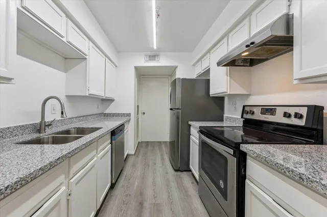 a kitchen with stainless steel appliances granite countertop a sink stove and refrigerator