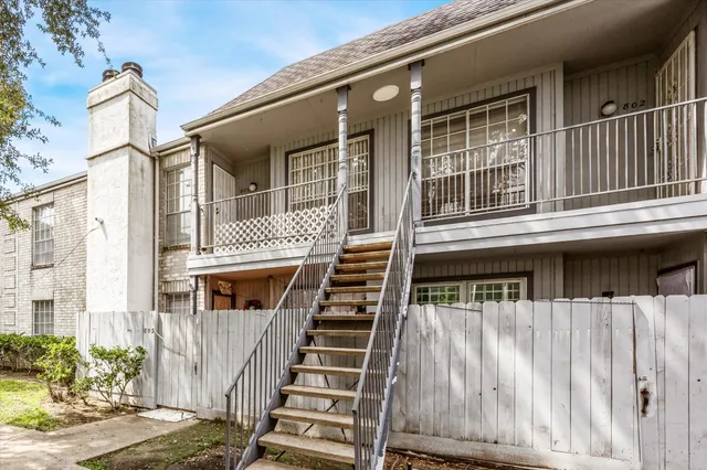 a front view of a house with iron stairs
