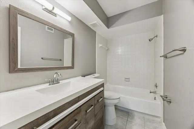 a bathroom with a bathtub shower sink vanity mirror and toilet