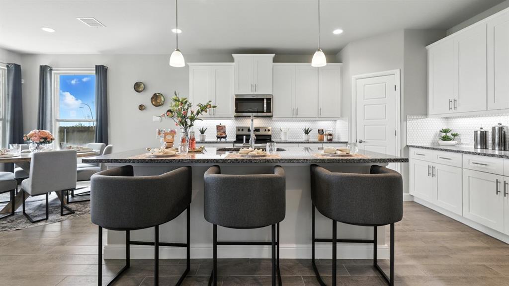 a kitchen with a dining table chairs sink and cabinets