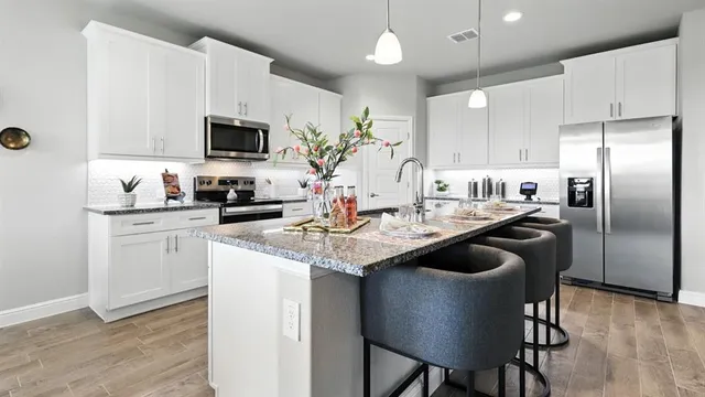 a kitchen with a sink cabinets and wooden floor