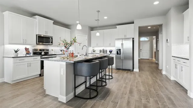 a kitchen with a dining table chairs sink and cabinets