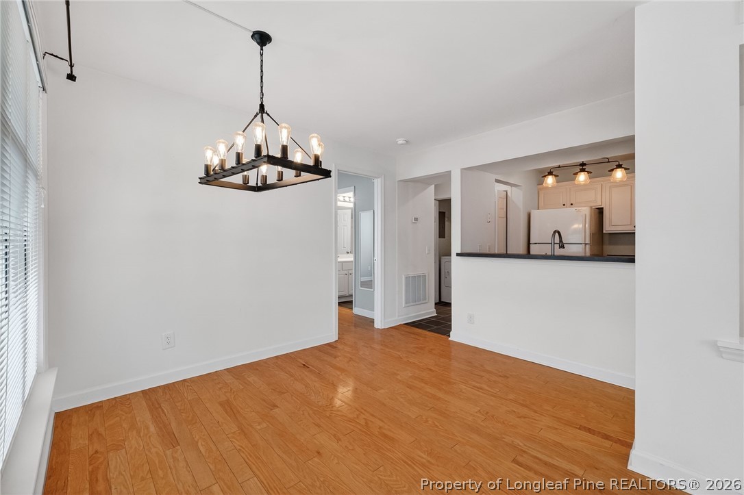1221 Westview Lane, Unit 301 Raleigh, NC 27605 - Photo 7 of 32 a view of a livingroom with wooden floor and chandelier