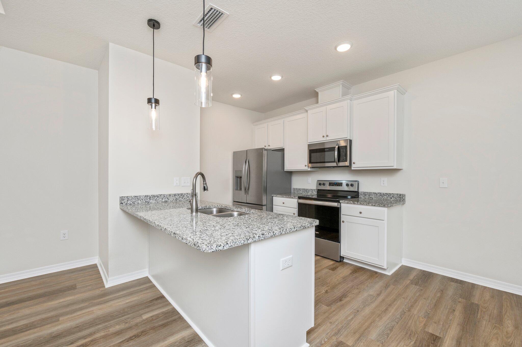 3156 Forrest Avenue Crestview, FL 32539 - Photo 11 of 44 a kitchen with stainless steel appliances granite countertop a sink a stove a microwave and a refrigerator