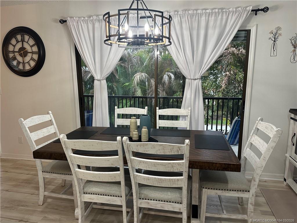 4095 Southeast Centerboard Lane, Unit 6B Stuart, FL 34997 - Photo 16 of 83 a view of a dining room with furniture wooden floor and chandelier